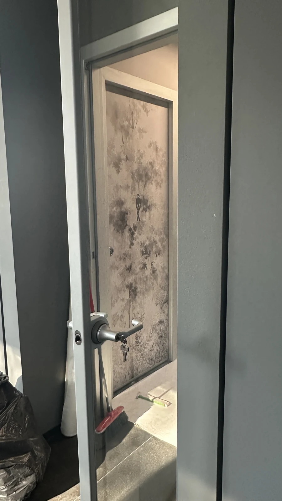 Porta aperta dei servizi con rivestimento botanico