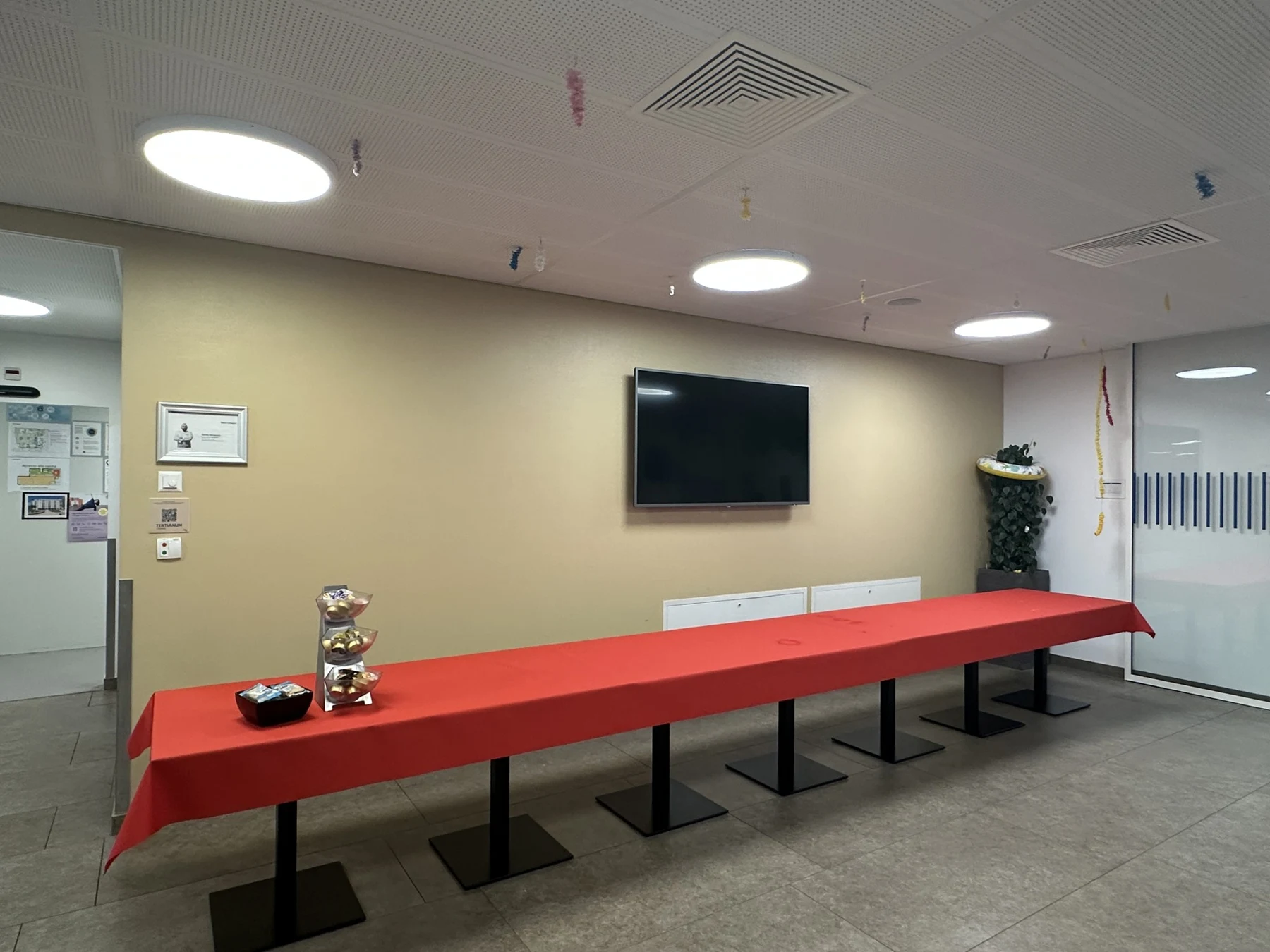 Sala prima della decorazione, con parete beige e televisore